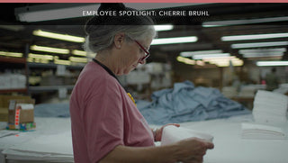 Cherrie Bruhl, a valued Red Land Cotton employee, smiling proudly in the office, highlighting her dedication to the company