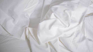 Close-up of high-quality cotton fabric with visible thread count detail, demonstrating the importance of thread count in creating luxurious bedding.